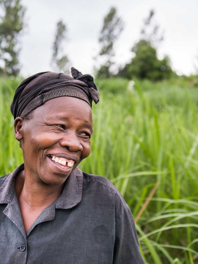 A woman smiles wide while looking to left of the camera
